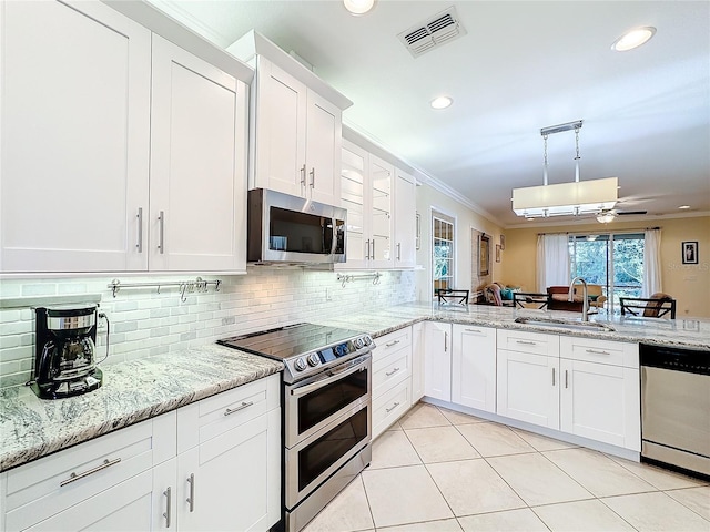 kitchen with white cabinetry, sink, stainless steel appliances, crown molding, and light tile patterned floors