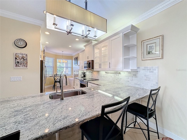 kitchen featuring white cabinets, a kitchen breakfast bar, stainless steel appliances, and sink