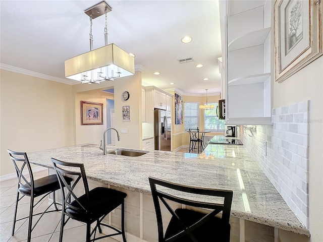 kitchen with backsplash, light stone counters, sink, and appliances with stainless steel finishes