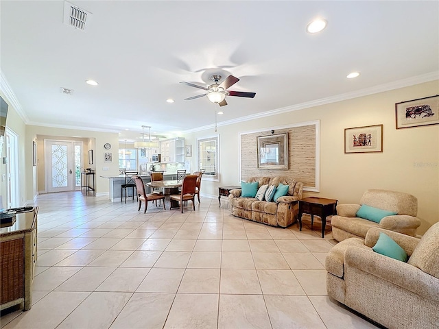 living room with ceiling fan, ornamental molding, and light tile patterned floors