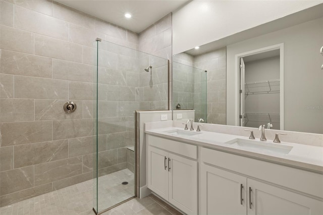 bathroom with vanity, tile patterned flooring, and a tile shower