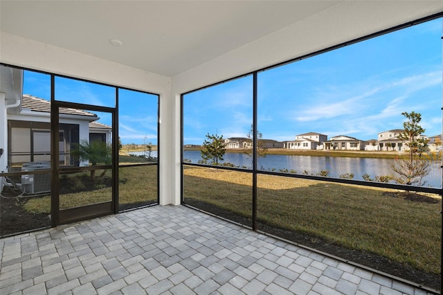 unfurnished sunroom featuring a water view