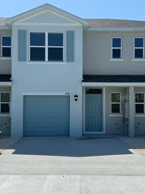 4588 Pleasant Ave, Palm Harbor, FL 34683 - view of property featuring stucco siding, an attached garage, driveway, and a shingled roof