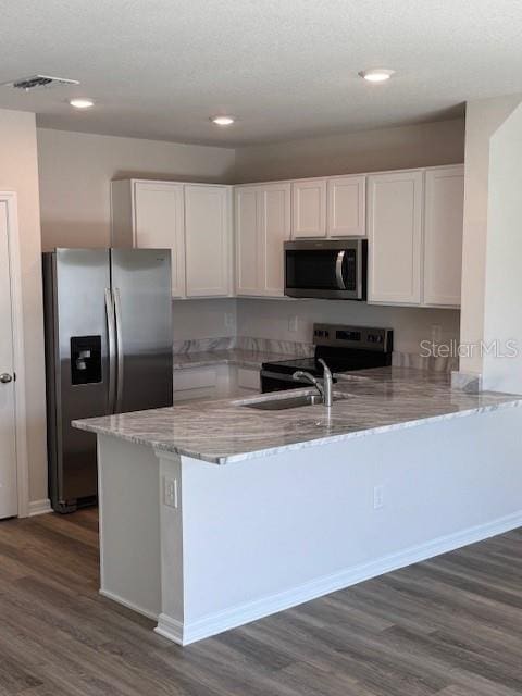 4588 Pleasant Ave, Palm Harbor, FL 34683 - kitchen featuring stainless steel appliances, a peninsula, white cabinetry, light stone counters, and recessed lighting