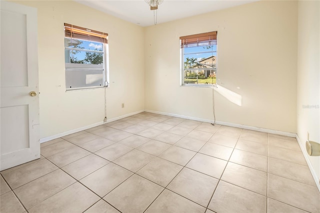 empty room with a healthy amount of sunlight and light tile patterned flooring