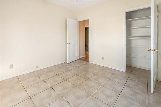 unfurnished bedroom with a closet and light tile patterned floors