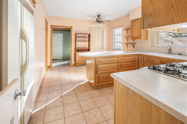 kitchen with kitchen peninsula, white fridge, ceiling fan, and light tile patterned flooring