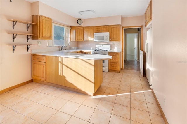 kitchen featuring kitchen peninsula, sink, light tile patterned floors, and white appliances