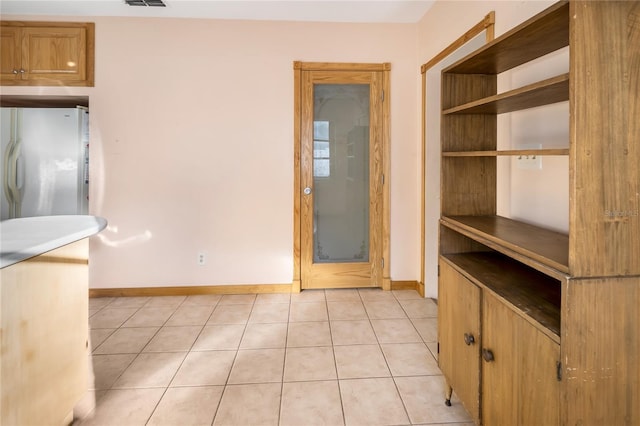 interior space with light tile patterned floors and white refrigerator