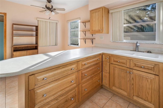 kitchen featuring kitchen peninsula, ceiling fan, sink, and light tile patterned floors