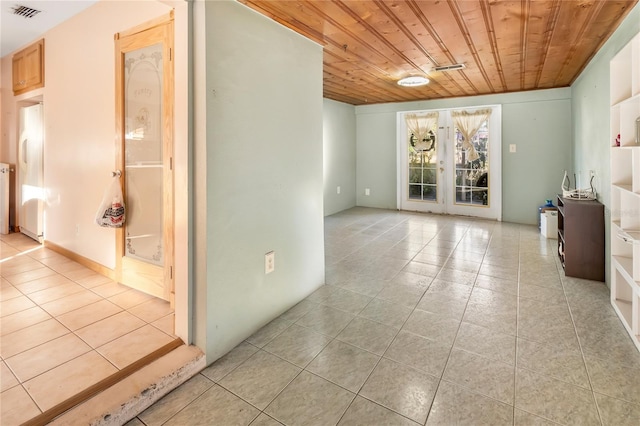 tiled spare room featuring french doors and wood ceiling