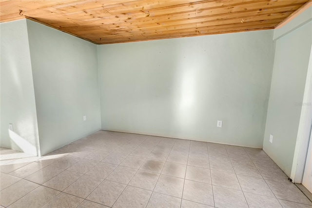 spare room featuring light tile patterned flooring and wood ceiling