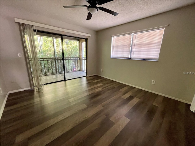 spare room with dark wood-type flooring, ceiling fan, a healthy amount of sunlight, and a textured ceiling