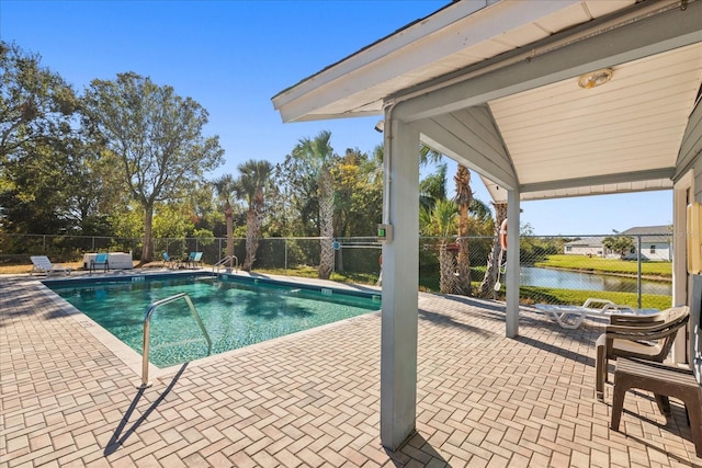 view of swimming pool with a patio area and a water view