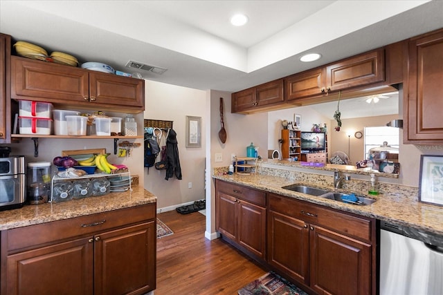 kitchen with dishwasher, sink, light stone counters, and dark wood-type flooring