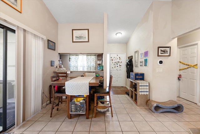 tiled dining room featuring a towering ceiling