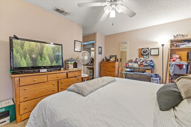 bedroom featuring ceiling fan, carpet floors, and a textured ceiling