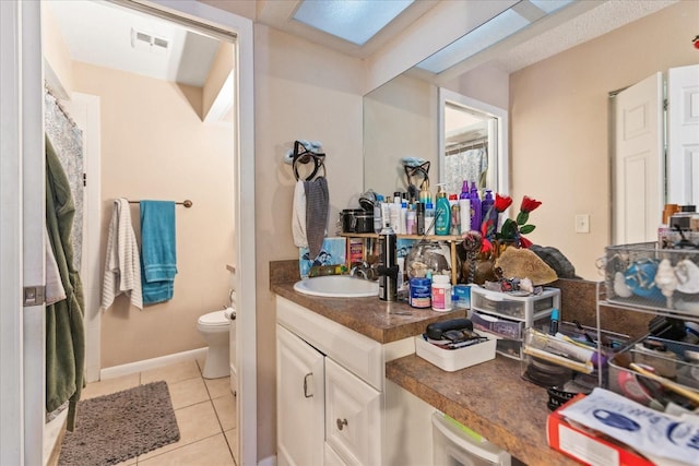 bathroom with tile patterned flooring, vanity, and toilet