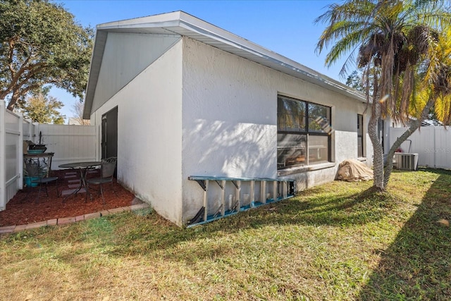 view of side of property with cooling unit and a yard