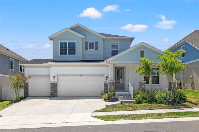 view of front of house featuring driveway, stone siding, and stucco siding