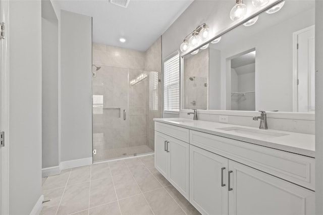 bathroom featuring a sink, tile patterned flooring, a walk in closet, and a shower stall