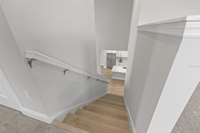 stairway with baseboards and wood finished floors