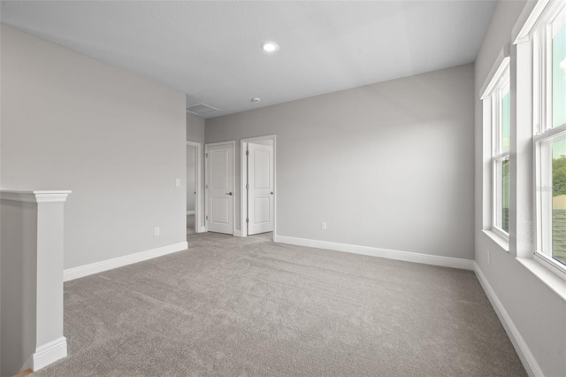 spare room with recessed lighting, light carpet, and baseboards