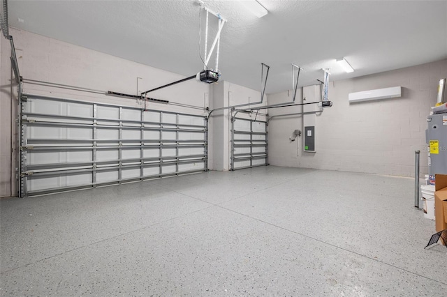 garage featuring a garage door opener, concrete block wall, and electric panel