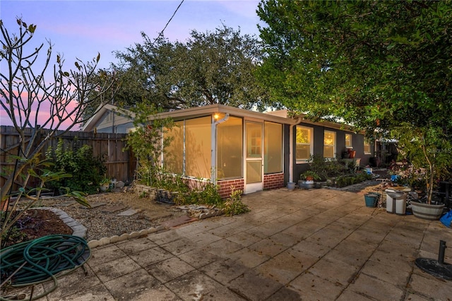 back house at dusk with a patio