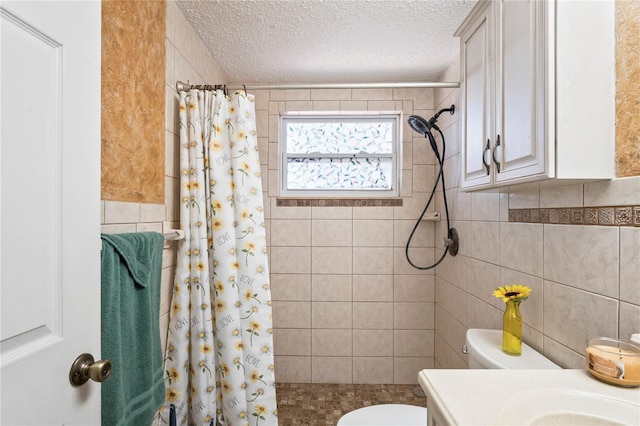 bathroom with vanity, a shower with curtain, toilet, a textured ceiling, and tile walls