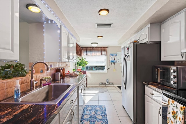 kitchen featuring white cabinets, light tile patterned floors, tasteful backsplash, and sink