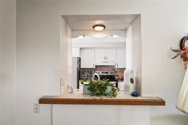 kitchen with backsplash, white cabinets, and appliances with stainless steel finishes