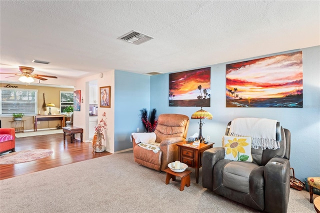 living area featuring hardwood / wood-style floors, a textured ceiling, and ceiling fan