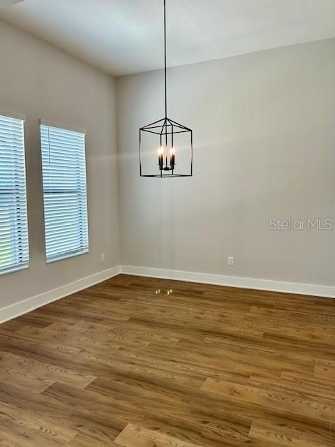 13400 Haflinger Way, Hudson, FL 34667 - spare room with a chandelier and wood finished floors