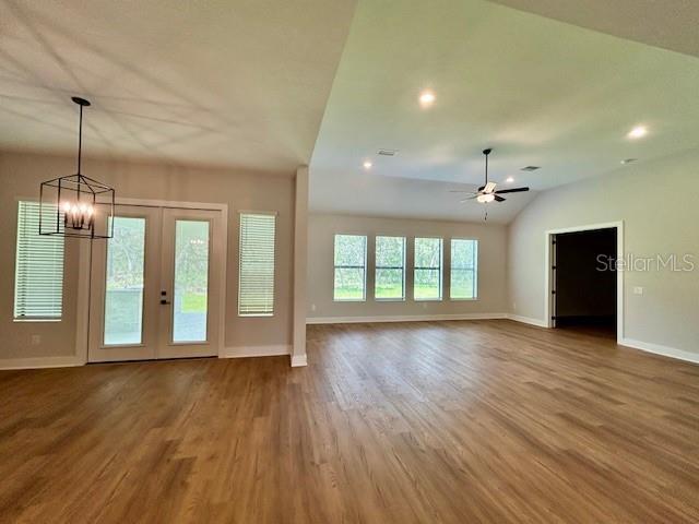 13400 Haflinger Way, Hudson, FL 34667 - unfurnished living room with wood finished floors, a chandelier, a ceiling fan, recessed lighting, and lofted ceiling
