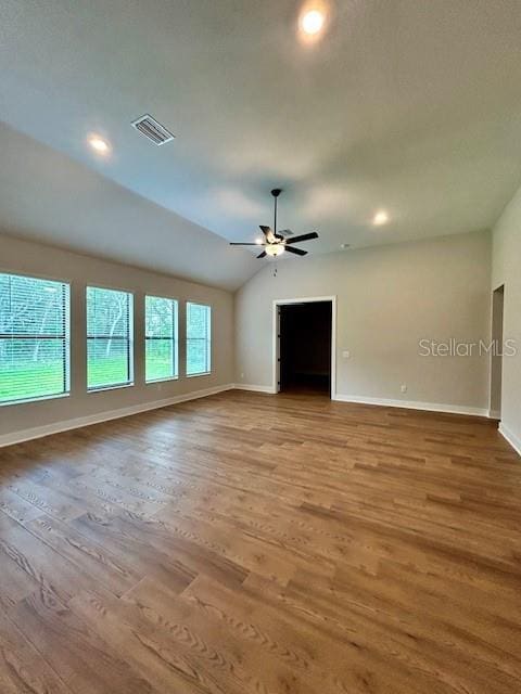 13400 Haflinger Way, Hudson, FL 34667 - unfurnished living room with wood finished floors, ceiling fan, vaulted ceiling, and recessed lighting