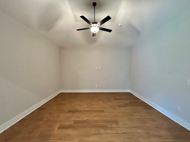 13400 Haflinger Way, Hudson, FL 34667 - spare room featuring vaulted ceiling, a ceiling fan, and wood finished floors