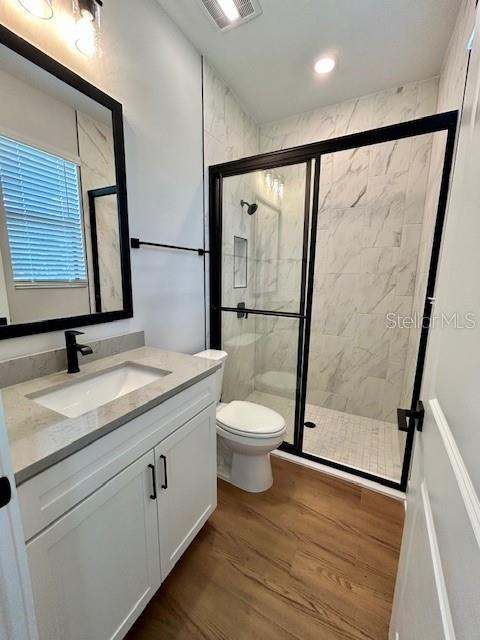 13400 Haflinger Way, Hudson, FL 34667 - bathroom with vanity, a stall shower, wood finished floors, and recessed lighting