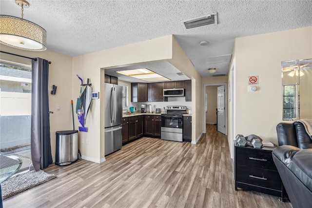 kitchen featuring plenty of natural light, dark brown cabinetry, light wood-type flooring, and appliances with stainless steel finishes