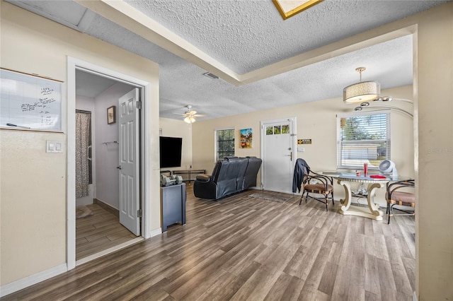 interior space with a textured ceiling, hardwood / wood-style flooring, and ceiling fan