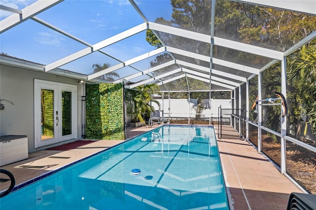 view of swimming pool featuring french doors, glass enclosure, and a patio area