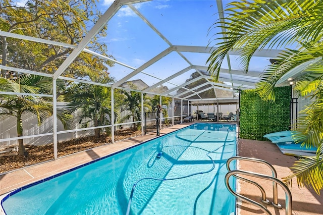 view of swimming pool featuring glass enclosure and a patio area