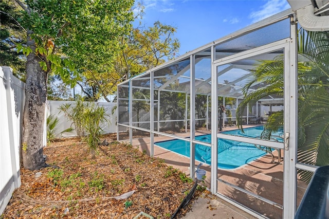 view of pool featuring glass enclosure