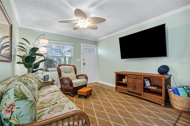 living room featuring hardwood / wood-style flooring, ceiling fan, ornamental molding, and a textured ceiling