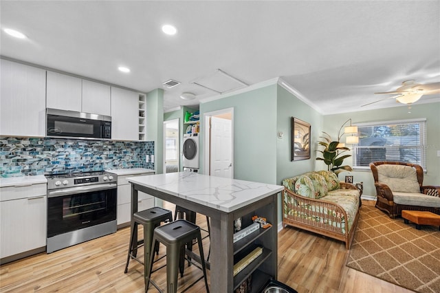 kitchen featuring white cabinetry, crown molding, light hardwood / wood-style floors, and appliances with stainless steel finishes