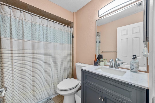 bathroom featuring vanity, toilet, and curtained shower