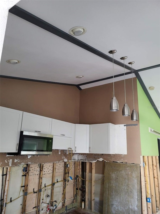 interior space with white cabinets and pendant lighting