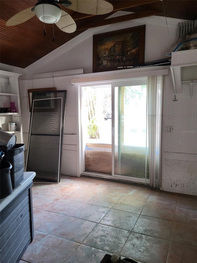 kitchen featuring vaulted ceiling, ceiling fan, and wood walls