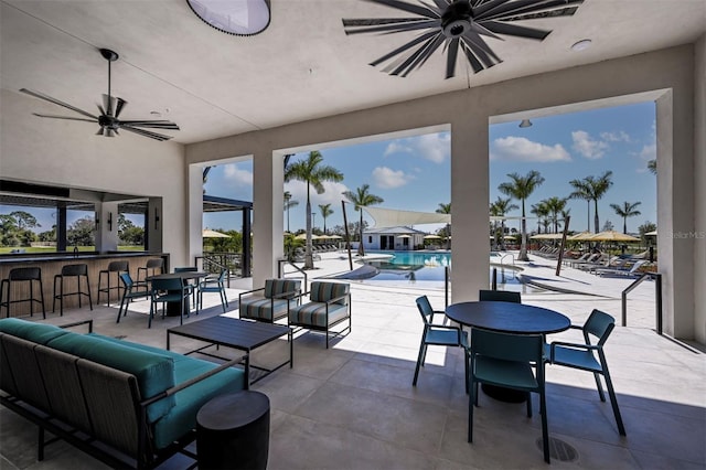 view of patio featuring a community pool, outdoor lounge area, an outdoor bar, and ceiling fan