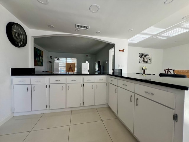 kitchen featuring white cabinets, light tile patterned floors, and kitchen peninsula